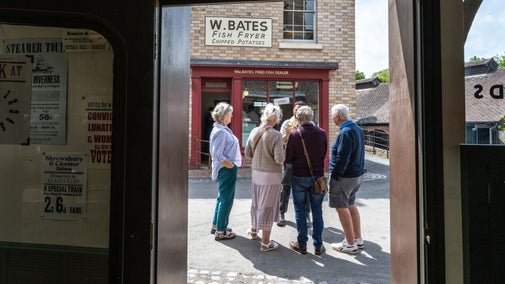 Visitors chatting with a guide at Blists Hill Victorian Town, Ironbridge Gorge, Shropshire